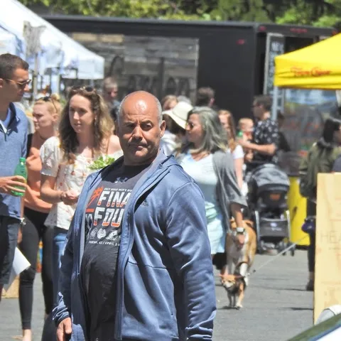 Street market with a man in a blue hoodie in the foreground